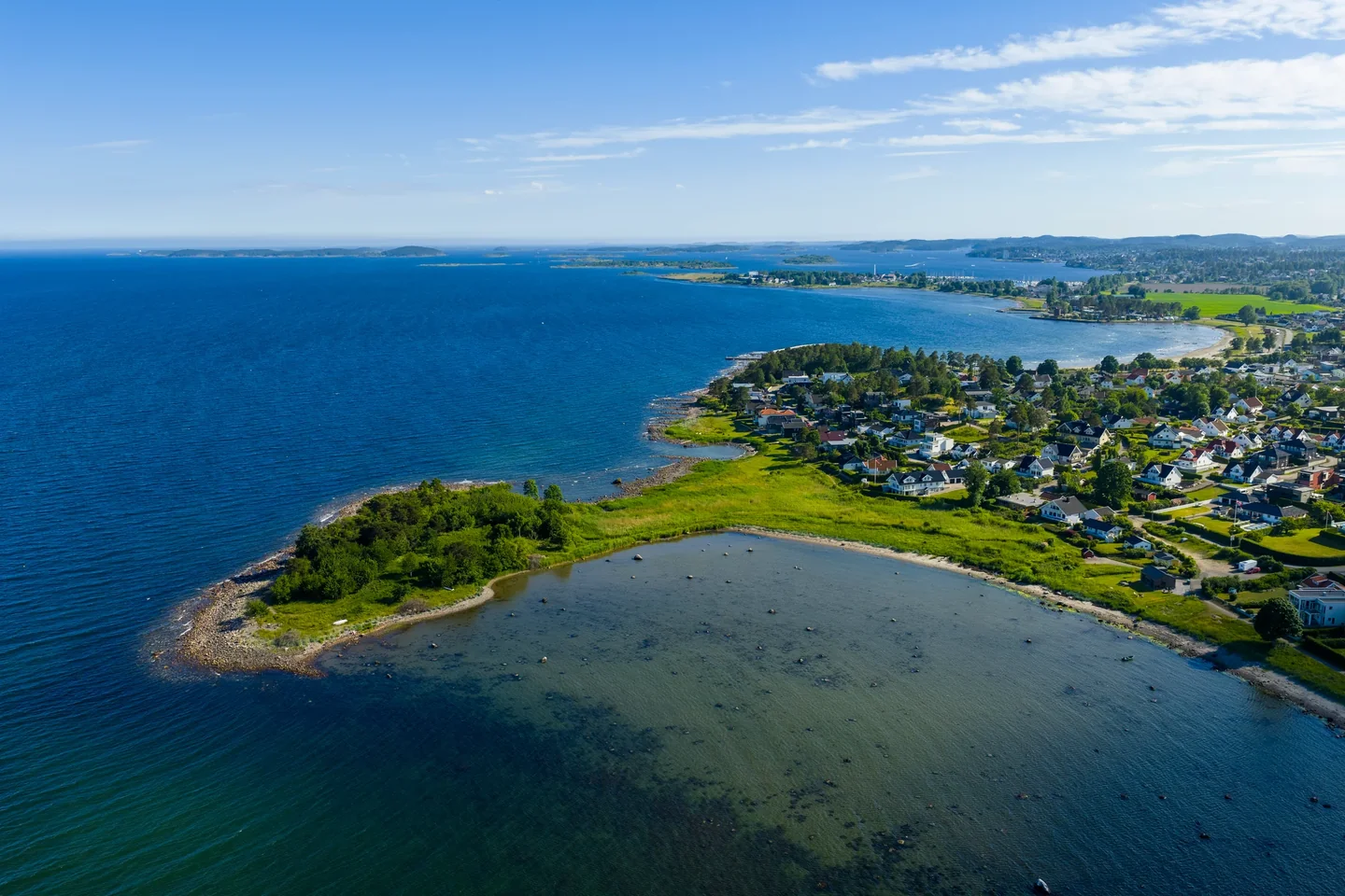 Kystlandskap ved Skallevold med viker, svaberg, bebyggelse og åpen sjø