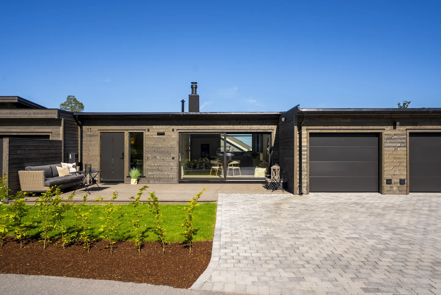 Ringshaughøyden 11 med inngangsparti, terrasse, hage og integrert garasje.
