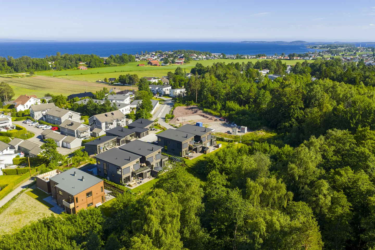 Droneoversikt over Ringshaughøyden, skogen, Ringshaugstranda og skjærgården utenfor.